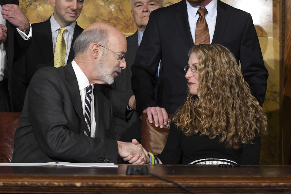 Pennsylvania Gov. Tom Wolf of Pennsylvania shakes the hand of Evelyn Piazza after signing anti-hazing legislation inspired by Piazza's son, Penn State student Tim Piazza who died after a night of drinking in a fraternity house, Friday, Oct. 19, 2018 in Harrisburg, Pa. (AP Photo/Marc Levy)