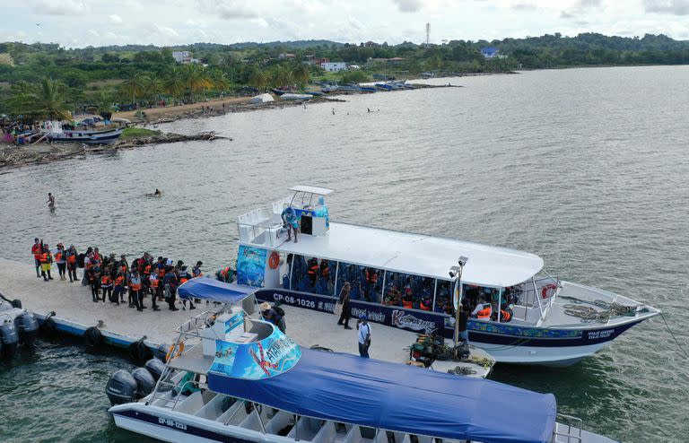 Migrantes venezolano suben al barco para seguir camino desde el puerto colombiano de Necoclí