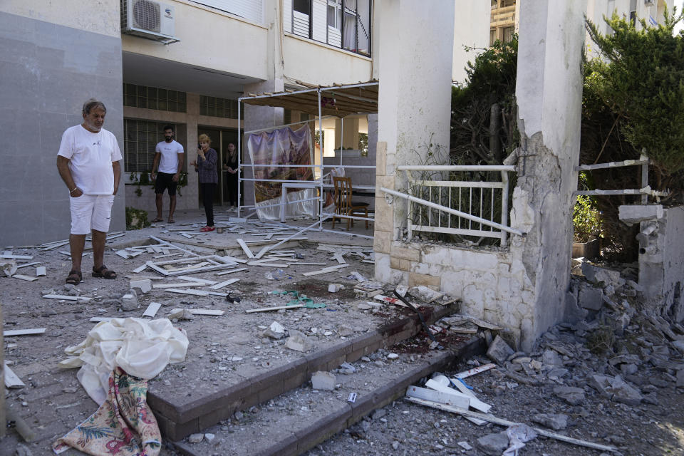 Residentes comprueban los daños causados por un ataque con proyectiles lanzados desde la Franja de Gaza, en Ashkelon, Israel, el 7 de octubre de 2023. (AP Foto/Ohad Zwigenberg)