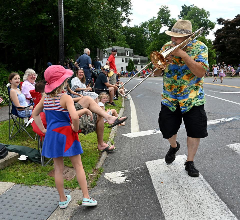 Steve Curtis, a trombone player with the New Magnolia Jazz Band, serenades a youngster during the 2022 version of the Sudbury Fourth of July Parade.