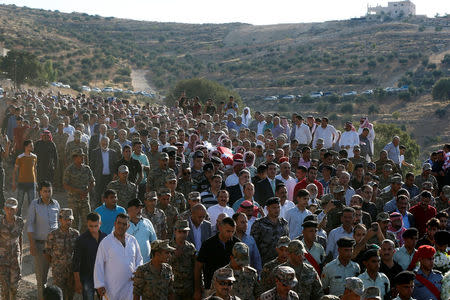 Guard of honor and relatives of Sergeant Hisham Aqarbeh, of the anti-terrorist unit, who was killed in an attack yesterday, carry his body during his funeral in Birayn in the city of Zarqa, Jordan, August 12, 2018.REUTERS/Muhammad Hamed