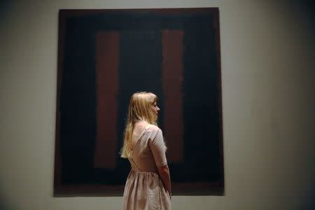 A member of Tate staff poses with the restored Mark Rothko artwork "Black on Maroon, 1958" at the Tate Modern in London May 13, 2014. REUTERS/Luke MacGregor