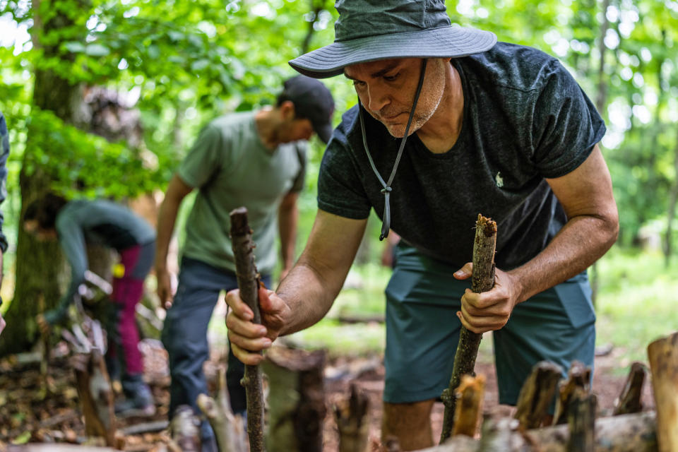 David D'Alessio, from Harlem, New York City, helps to build a debris hut shelter at the Mountain Scout Survival School. (Michael Rubenstein / for NBC News)