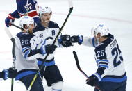 Winnipeg Jets' Paul Stastny, right, celebrates his goal against the Montreal Canadiens with teammates Blake Wheeler, left, and Mark Scheifele during first-period NHL hockey game action in Montreal, Thursday, March 4, 2021. (Paul Chiasson/The Canadian Press via AP)