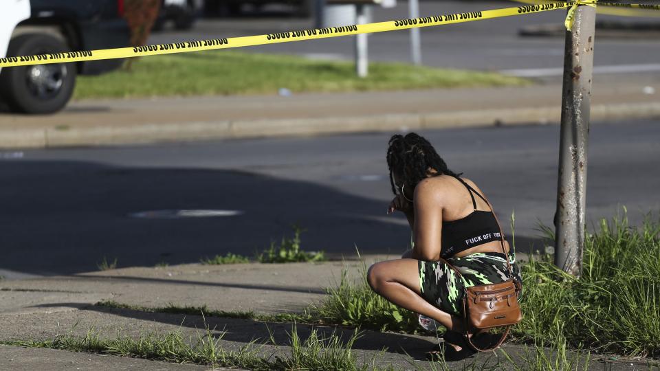 A bystander watches as police investigate after a shooting at a supermarket on Saturday, May 14, 2022, in Buffalo, N.Y.