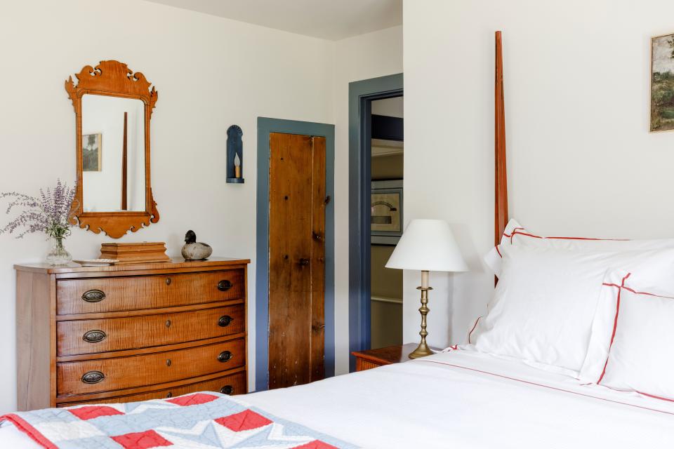 In a guest bedroom dubbed the “red room,” heirloom wood furniture takes center stage. The dresser is an 18th-century tiger maple bow front, the mirror is a Chippendale (also in tiger maple), and the bed is a painted American antique.