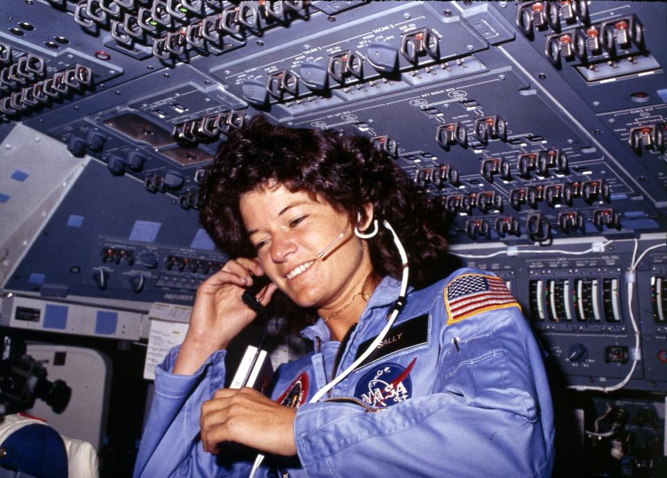 Sally Ride in a spacecraft with a headset on.