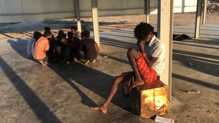 Migrants are seen rescued by Libyan coast guard after their wooden boat capsized off the coast of Komas, a town east of the capital Tripoli