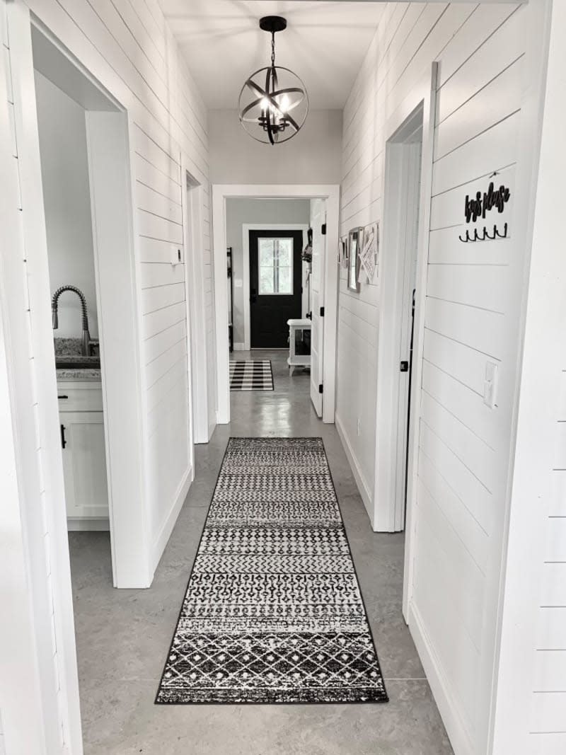 white shiplap hallway with black and white runner rug