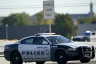 Emergency responders stage near Dallas Executive Airport where two historic military planes collided and crashed during an airshow in Dallas on Saturday, Nov. 12, 2022. (AP Photo/LM Otero)