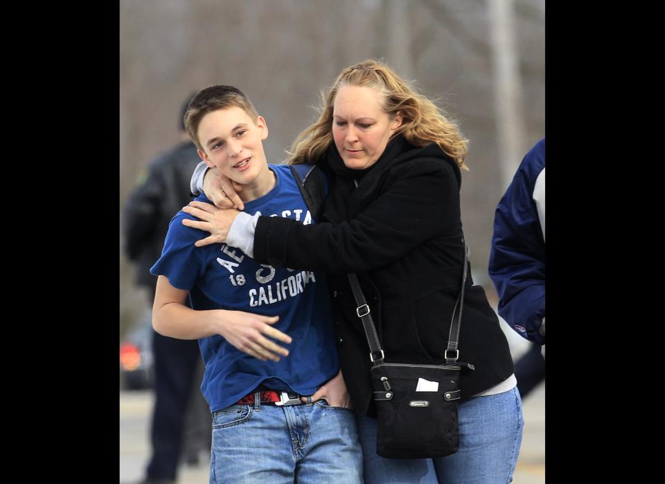 Doug Gasper, a ninth-grader at Chardon High School, is hugged by his mother, Sandy, as they leave Maple Elementary School Monday, Feb. 27, 2012, in Chardon, Ohio. Students assembled at Maple Elementary School after a shooting took place at the high school. A gunman opened fire inside the high school's cafeteria at the start of the school day, killing three students and wounding two others, officials said. A suspect is in custody. (AP Photo/Tony Dejak)