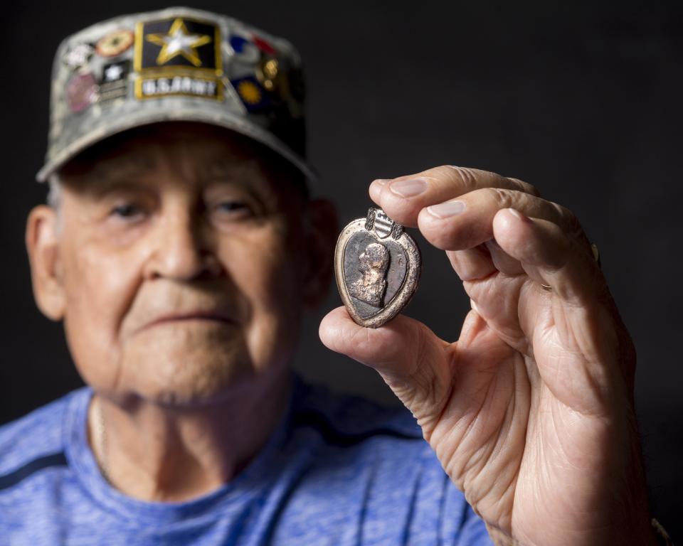 The late Army veteran Felix Diaz holds a Purple Heart that was found in the desert near the historic Oro Grande Cemetery in this 2018 photo. The medal belonged to Army Lt. Manuel P. Rodriguez, an Oro Grande resident who died in World War II.