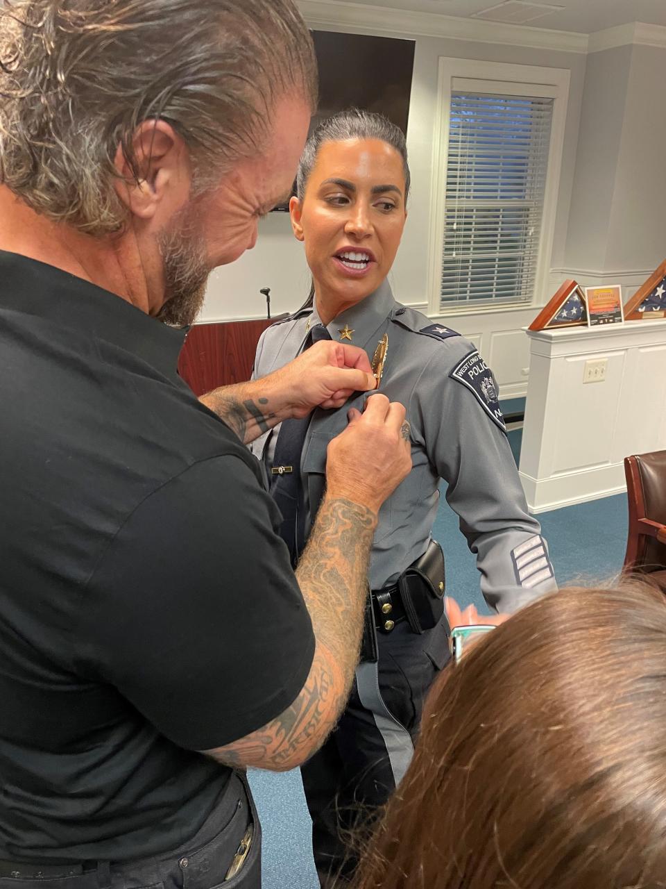 Thomas Patten pins the police chief badge on his wife Marlowe Botti, the new police chief for West Long Branch. Botti became the first female police chief in the borough's 115-year history.