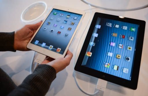 A customer compares an iPad mini (L) to an iPad at an Apple store in Rome. In tablets, Apple's market share has fallen to just over 50 percent from 65 percent in the second quarter as Android devices gain ground, according to IDC figures