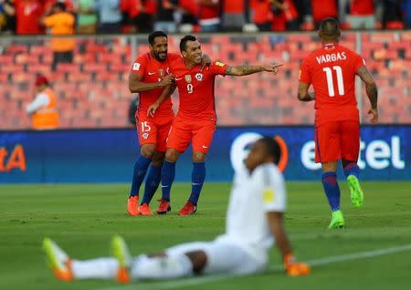 El delantero chileno Esteban Paredes (centro) celebra junto a sus compañeros Jean Beausejour (derecha) y Eduardo Vargas uno de sus goles ante Venezuela en el Estadio Monumental de Santiago, Chile, Marzo 28. La selección chilena de fútbol venció el martes 3-1 a Venezuela con un doblete del delantero Esteban Paredes y retornó a puestos de clasificación directa para el Mundial a falta de cuatro fechas para el término de las eliminatorias. REUTERS/Ivan Alvarado