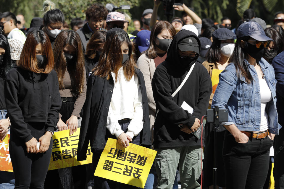 Pro-democracy supporters pause during a rally by the advertising industry in Hong Kong on Monday, Dec. 2, 2019. Thousands of people took to Hong Kong's streets Sunday in a new wave of pro-democracy protests, but police fired tear gas after some demonstrators hurled bricks and smoke bombs, breaking a rare pause in violence that has persisted during the six-month-long movement. Card reads "All citizen boycott, Advertising Industry" (AP Photo/Vincent Thian)