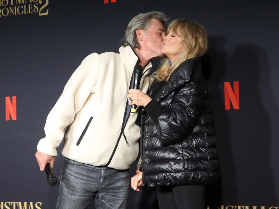 Kurt Russell gives Goldie Hawn a smooch at Netflix's "The Christmas Chronicles: Part Two" drive-in event in Los Angeles.