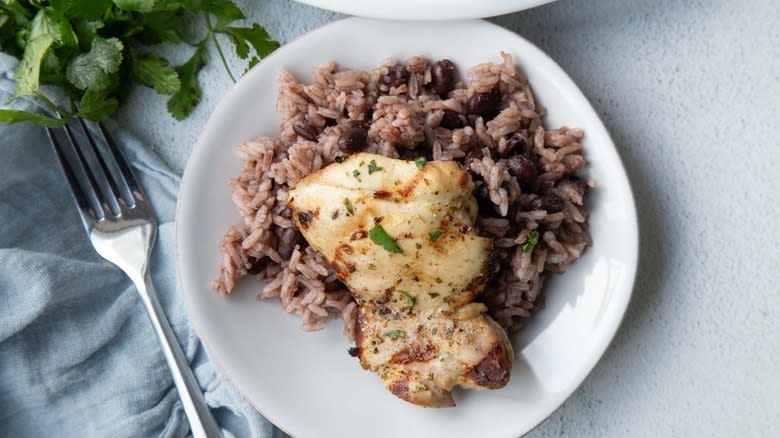 chicken with rice and beans on white plate