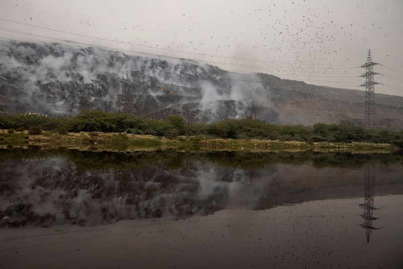 Smoke billows from burning garbage at the Ghazipur landfill site in New Delhi