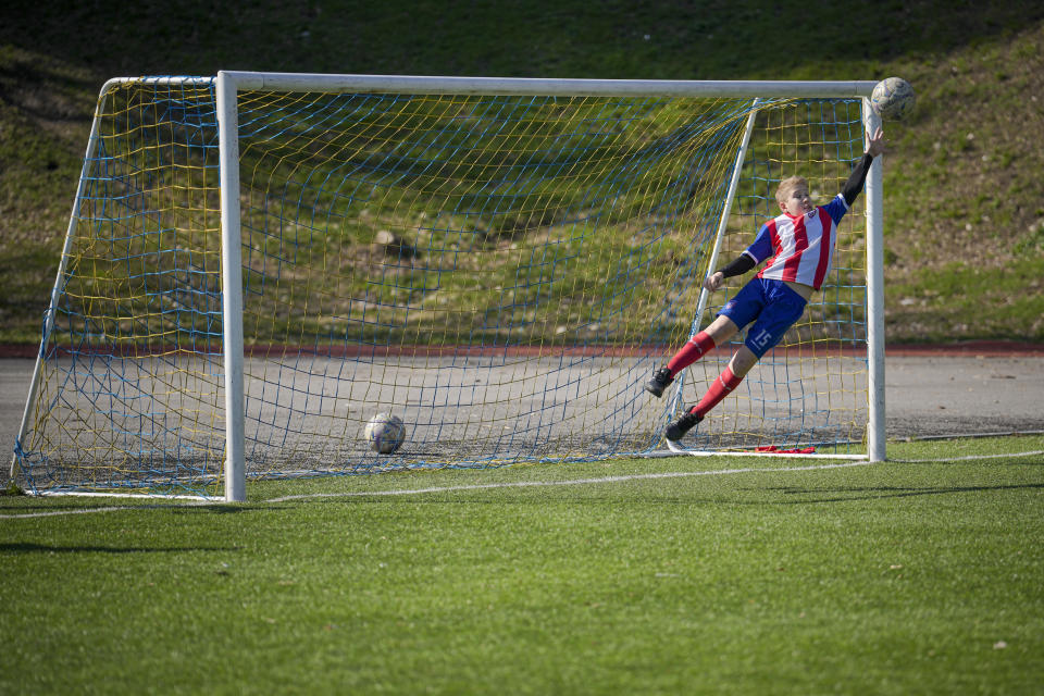 A child jumps to catch a ball during a soccer training session in Kyiv, Ukraine, Wednesday, March 27, 2024. Ukraine, Georgia and Poland are going to the 2024 European Championship after bringing late drama to win emotional qualifying playoffs on Tuesday. (AP Photo/Vadim Ghirda)