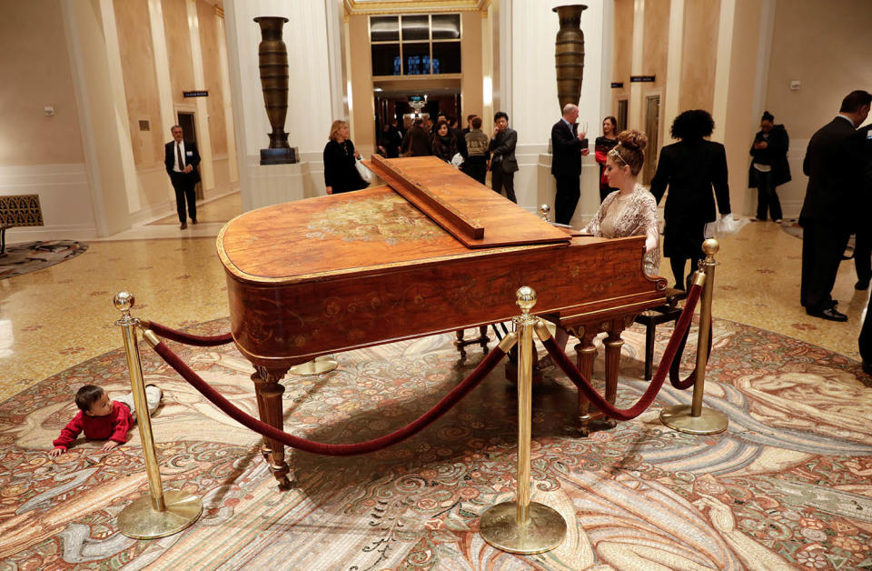 <p>A woman plays the piano for guests as a baby looks on from the floor in the entrance lobby of the Waldorf Astoria hotel in New York, Feb. 28, 2017. (Photo: Mike Segar/Reuters) </p>