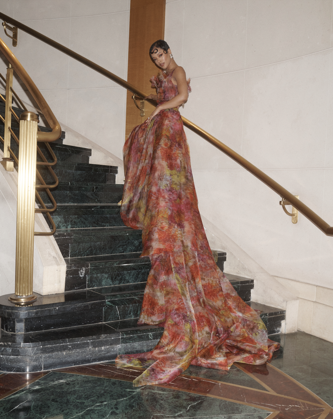 a woman wearing a floral dress in a hotel suite