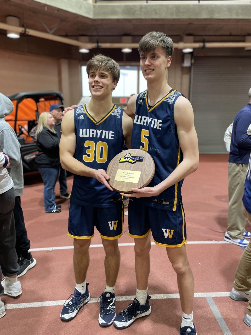Wayne senior PJ Ostrowsk, left, and Cam Blankenberg with the NYSPHSAA Class A region plaque after defeating Section VI's Williamsville South 58-41 on Saturday, March 9, 2024 at Buffalo State.