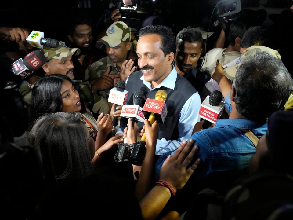 S. Somanath mustached man smiles surrounded by reporters with microphones in his face