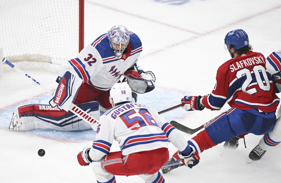 New York Rangers goaltender Jonathan Quick stops Montreal Canadiens' Juraj Slafkovsky (20) as Rangers' Erik Gustafsson defends during the third period of an NHL hockey game in Montreal, Saturday, Jan. 6, 2024. (Graham Hughes/The Canadian Press via AP)