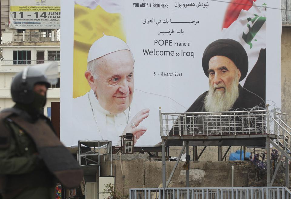 Un soldado iraquí en guardia junto a un cartel de Francisco y el gran  ayatollah Ali Sistani en el centro de Bagdad, la capital iraquí, una ciudad y un país con un pasado reciente bañado en sangre 