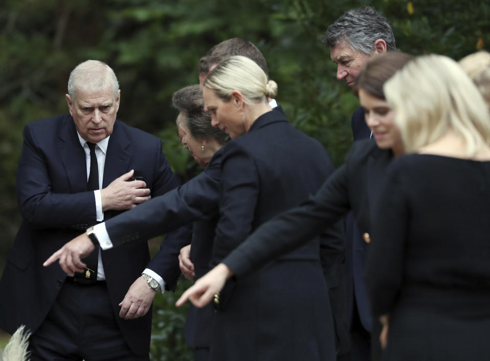 Britain's Prince Andrew looks at floral tributes for Queen Elizabeth II, outside the gates of Balmoral Castle in Aberdeenshire, Scotland Saturday, Sept. 10, 2022. Queen Elizabeth II, Britain's longest-reigning monarch and a rock of stability across much of a turbulent century, died Thursday after 70 years on the throne. She was 96. (AP Photo/Scott Heppell)