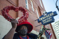 G.A. Breedlove holds up a heart outside of the historic Ebenezer First Baptist Church where Martin Luther King Jr. preached on Monday, Jan. 18, 2021, in honor of Martin Luther King Jr. Day, in Atlanta. (AP Photo/Branden Camp)