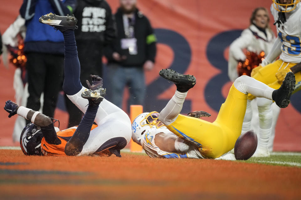 Denver Broncos wide receiver Jerry Jeudy (10) and Los Angeles Chargers safety Alohi Gilman (32) lies on the turf after Gilman broke up the play during the second half of an NFL football game, Sunday, Dec. 31, 2023, in Denver. Gilman was charged with interference against the Denver Broncos. (AP Photo/David Zalubowski)