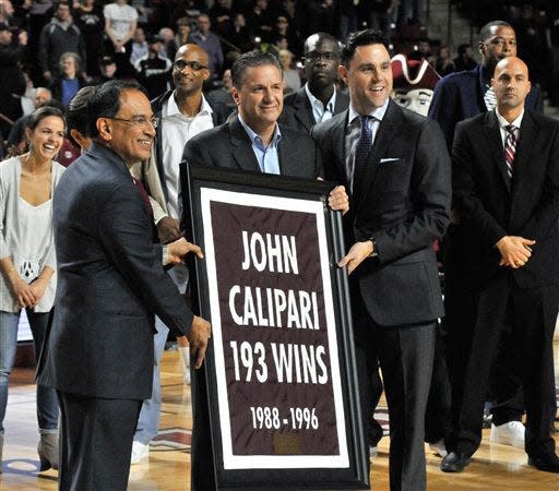 Former UMass basketball coach John Calipari, center, flanked by UMass chancellor Kumble Subbaswami, left, and athletic director Ryan Bamford during a banner-raising ceremony.