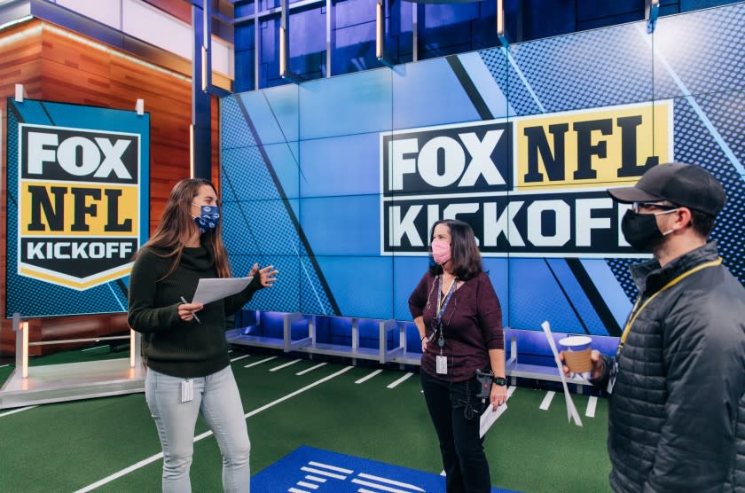 Fox NFL Kickoff director Courtney Stockmal, left, speaks to other producers in the show's studio.