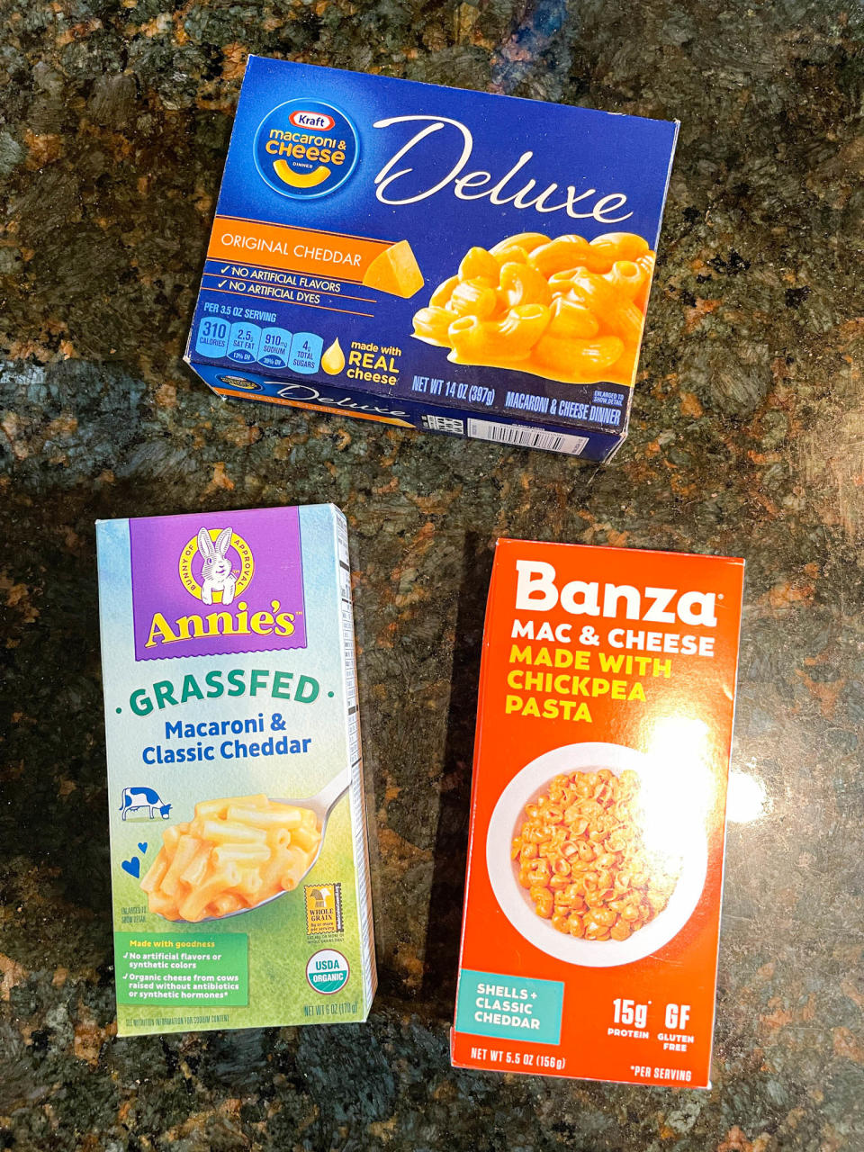 Three mac 'n' cheese boxes: Kraft Deluxe, Annie's Grassfed, and Banza