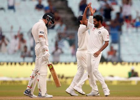 Cricket - India v New Zealand - Second Test cricket match - Eden Gardens, Kolkata, India - 01/10/2016. India's Bhuvneshwar Kumar (R) celebrates after taking the wicket of New Zealands' Mitchell Santner. REUTERS/Rupak De Chowdhuri