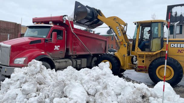 PHOTO: A front loader dumps snow into a dump truck along a residential street in Buffalo, New York, Dec. 29, 2022. (Carolyn Thompson/AP)