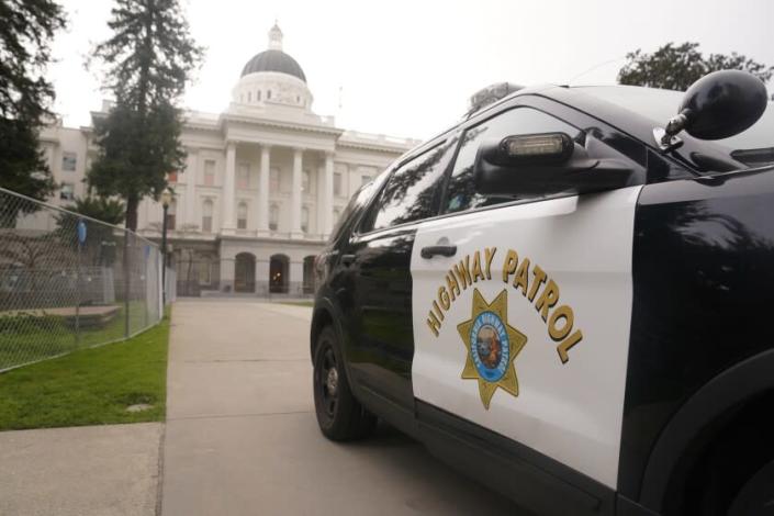 A California Highway Patrol vehicle is parked outside the state Capitol in Sacramento, Calif, Monday, Feb. 14, 2022. California Attorney General Rob Bonta says 54 current and former Highway Patrol Officers have been charge with racking up more than $226,000 in phony hours in an overtime fraud scheme. The charges, announced Thursday, Feb. 17, 2022, set from a criminal investigation of offices in the East Lost Angeles station. (AP Photo/Rich Pedroncelli)