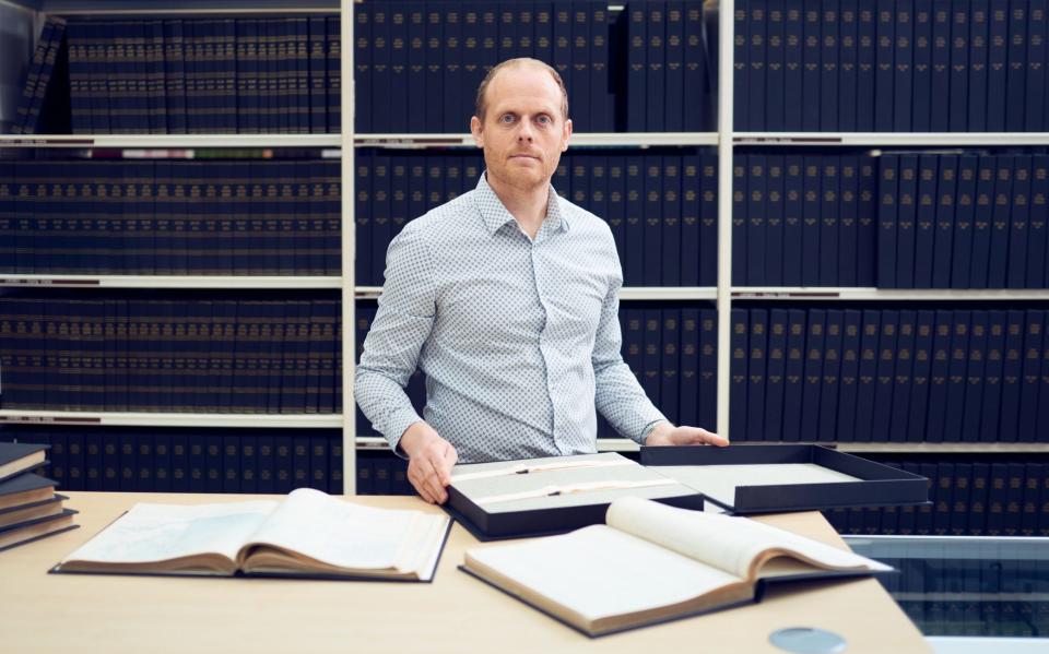 Mark McCarthy looking through historical records at the National Meteorological Library and Archive in Exeter - Gareth Iwan Jones