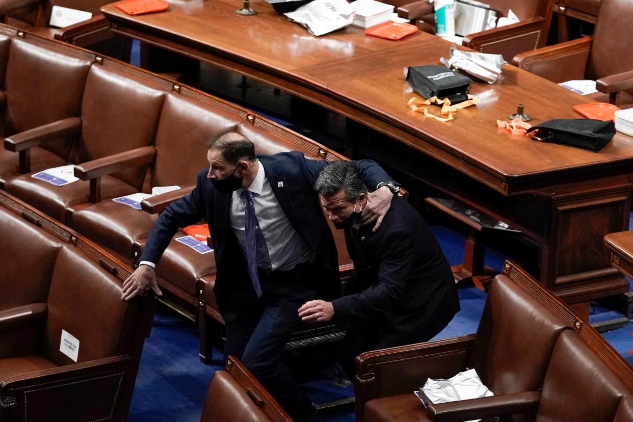 Lawmakers evacuate the floor as rioters try to break into the House Chamber at the U.S. Capitol on Wednesday, Jan. 6, 2021, in Washington.