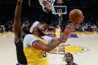 Los Angeles Lakers forward Anthony Davis (3) goes to basket under pressure from Sacramento Kings guard Terence Davis II (3) during the first half of an NBA basketball game in Los Angeles, Friday, Nov. 26, 2021. (AP Photo/Ringo H.W. Chiu)