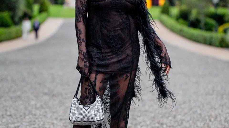 Yomi wears a black lace dress and a Prada bag