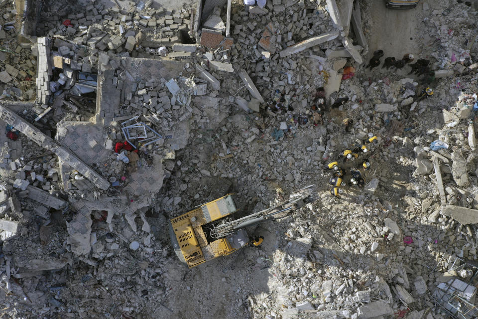 Rescuers search through the rubble of collapsed buildings in the town of Armanaz, Idlib province, Syria, Wednesday, Feb. 8, 2023. With the hope of finding survivors fading, stretched rescue teams in Turkey and Syria searched Wednesday for signs of life in the rubble of thousands of buildings toppled by a catastrophic earthquake. (AP Photo/Ghaith Alsayed)