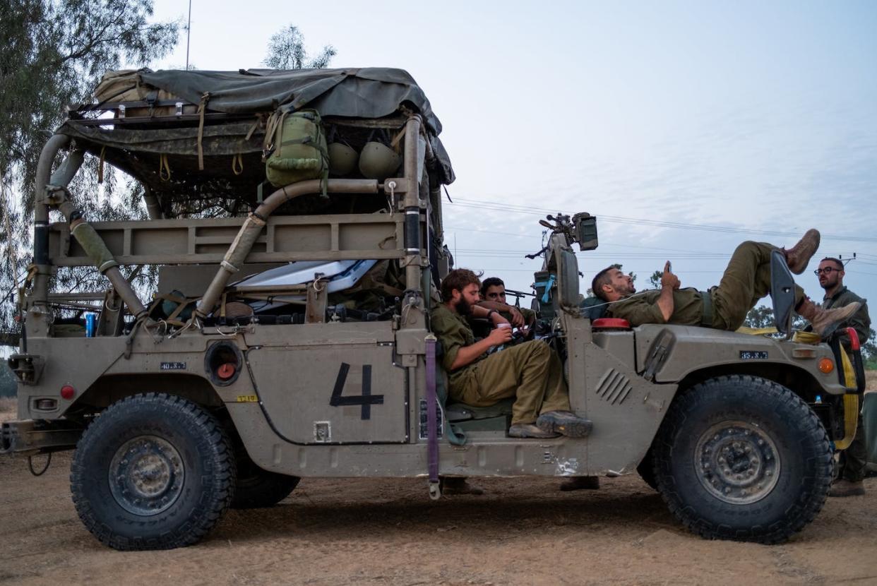 Israeli reservists take a moment to rest in southern Israel on Nov. 13, 2023. <a href="https://www.gettyimages.com/detail/news-photo/reservists-rest-on-a-military-vehicle-while-at-a-rest-stop-news-photo/1797440629" rel="nofollow noopener" target="_blank" data-ylk="slk:Alexi J. Rosenfeld/Getty Images;elm:context_link;itc:0;sec:content-canvas" class="link ">Alexi J. Rosenfeld/Getty Images</a>