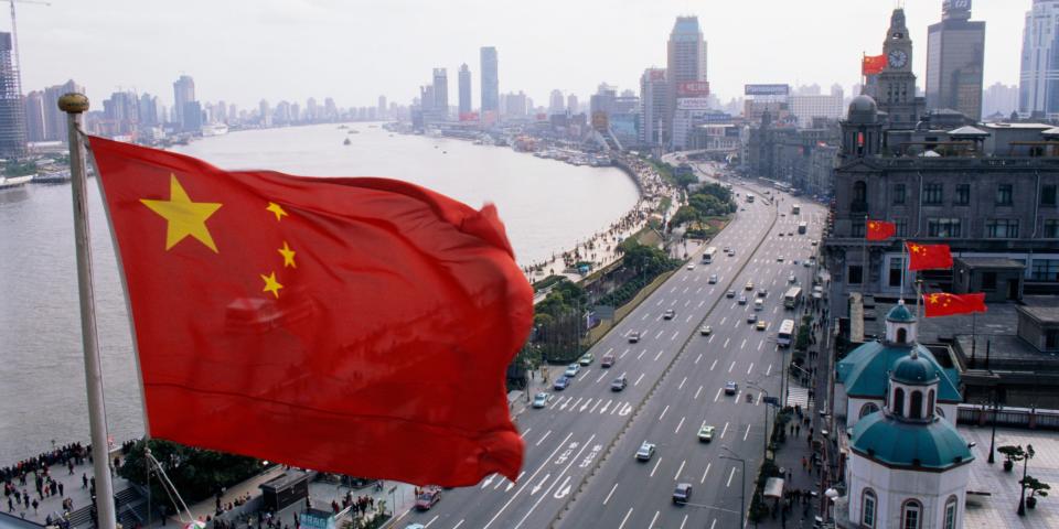 A Chinese flag flying over Shanghai street