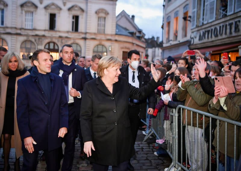 France's President Emmanuel Macron, flanked by his wife Brigitte Macron, arrives for talks with outgoing German Chancellor Angela Merkel, in Beaune