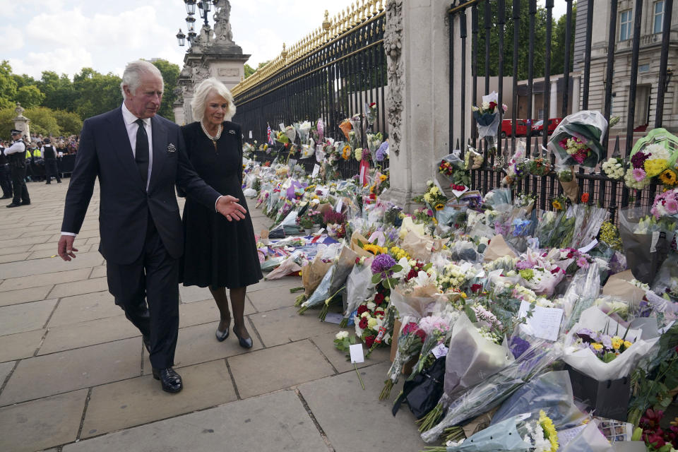 Britain's King Charles III, left, and Camilla, the Queen Consort, look at floral tributes outside Buckingham Palace following Thursday's death of Queen Elizabeth II, in London, Friday, Sept. 9, 2022. King Charles III, who spent much of his 73 years preparing for the role, planned to meet with the prime minister and address a nation grieving the only British monarch most of the world had known. He takes the throne in an era of uncertainty for both his country and the monarchy itself. (Yui Mok/Pool Photo via AP)