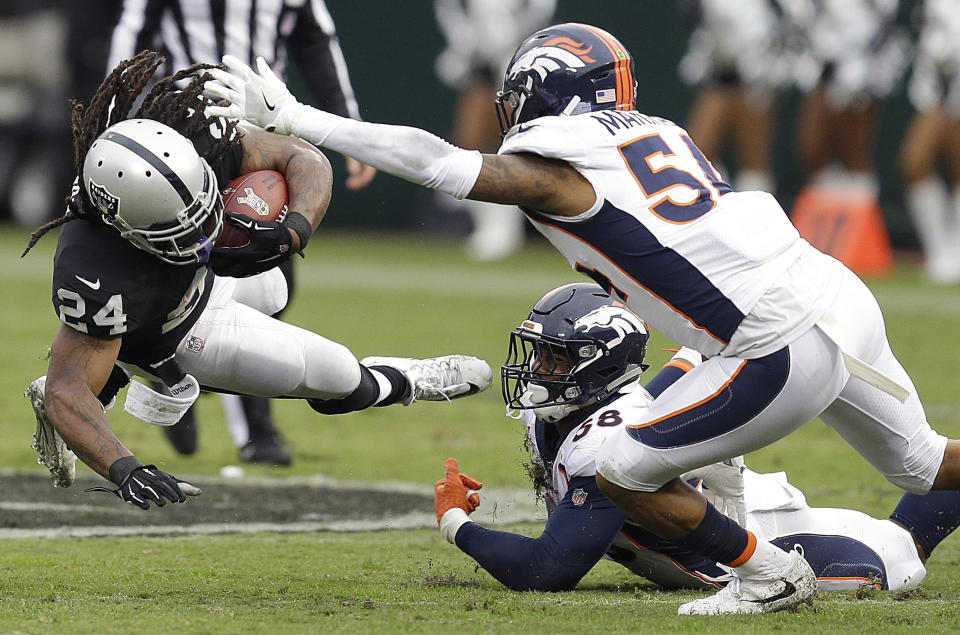 <p>Oakland Raiders running back Marshawn Lynch (24) falls forward next to Denver Broncos linebacker Brandon Marshall (54) and linebacker Von Miller (58) during the first half of an NFL football game in Oakland, Calif., Sunday, Nov. 26, 2017. (AP Photo/Ben Margot) </p>