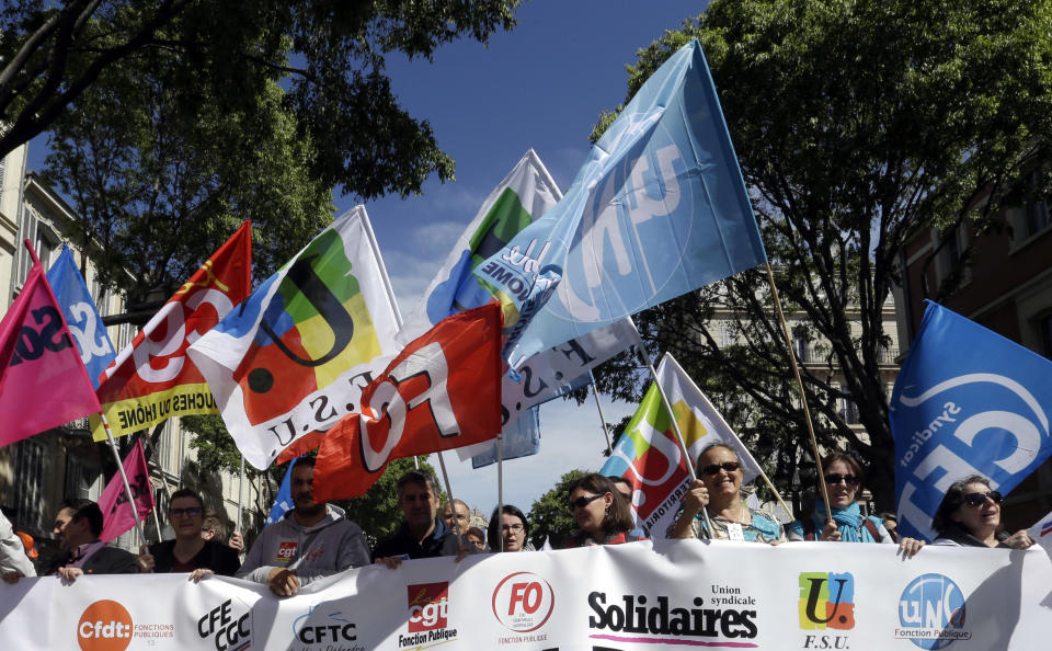 Public sector workers hold unions flags during a demonstration in Marseille, southern France, Thursday, May 9, 2019. French unions are holding strikes and protests against 120,000 job cuts and other deep changes to France's huge public sector by President Emmanuel Macron's government. (AP Photo/Claude Paris)